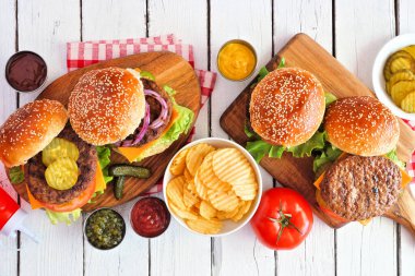 Barbekü hamburger masası sahnesi. Beyaz ahşap arka plan üzerinde görünüm.