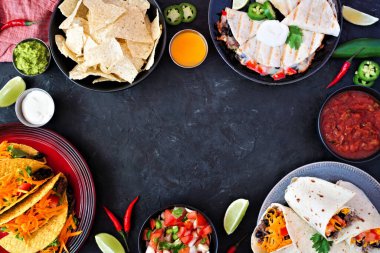 Meksika yemek çerçevesi, karanlık bir arkaplan üzerine manzaralı. Taco, nachos, quesadilla ve burrito. Boşluğu kopyala.