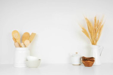 Mutfak gereçleri ve mutfak aletleri beyaz bir rafta ya da tezgahta fotokopi alanı olan beyaz bir duvar zeminine karşı. Ev mutfağı yemek dekorasyonu.