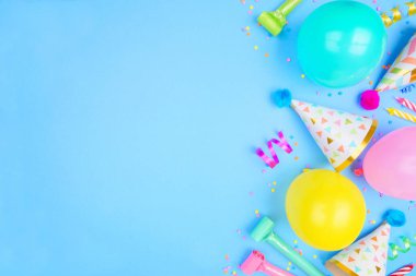 Mavi bir arka planda doğum günü partisi sınırı. Yukarıda konfeti, balon, parti şapkası ve flamalarla. Boşluğu kopyala.