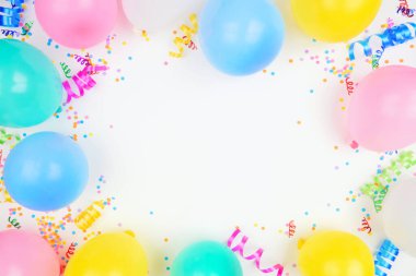 Beyaz bir arka planda doğum günü partisi temalı çerçeve. Balonlarla, konfetilerle ve flamalarla tepeden aşağıya bak. Boşluğu kopyala.