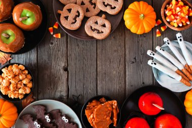 Köy cadılar bayramı çerçevesi koyu ahşap arka planda fotokopi alanı var. Genel bakış. Elma, kurabiye, şeker ve şeker seçimi.