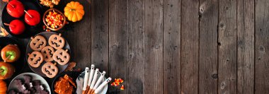 Köy Cadılar Bayramı 'nda köşe sınırında siyah ahşap bir afişin üzerinde fotokopi alanı var. Üst Manzara. Elma şekeri, kurabiye, şeker ve şeker çeşitleri.