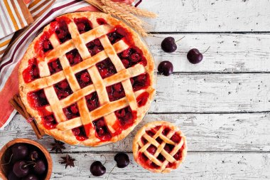 Kirazlı turtalar. Beyaz ahşap arka planda üst manzara sahnesi. Sonbahar yemekleri konsepti.