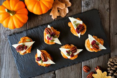 Sonbahar crostini aperatifleri, kabak ezmeli, peynir ve fındıklı. Kırsal ahşap arkaplanda en iyi görünüm tablosu.