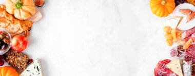 Sonbahar şarküteri beyaz mermer afiş arka planda çifte sınır. Çeşitli peynir ve mezeler. Boşluğu kopyala.