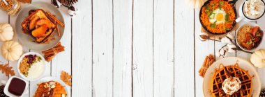 Sonbahar kahvaltısı ya da açık büfe açık büfe beyaz ahşap pankarta karşı çift taraflı. Kabak baharatlı waffle, krep, elmalı tost, yulaf ezmesi, yumurta tavası, yoğurt. Kopyalama alanı olan üst görünüm.