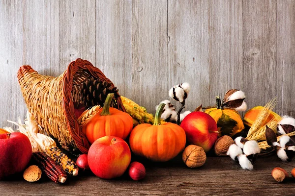 秋の果物や野菜でいっぱいの感謝祭の収穫コーヌコピア 素朴な灰色の木の背景に対するサイドビュー — ストック写真