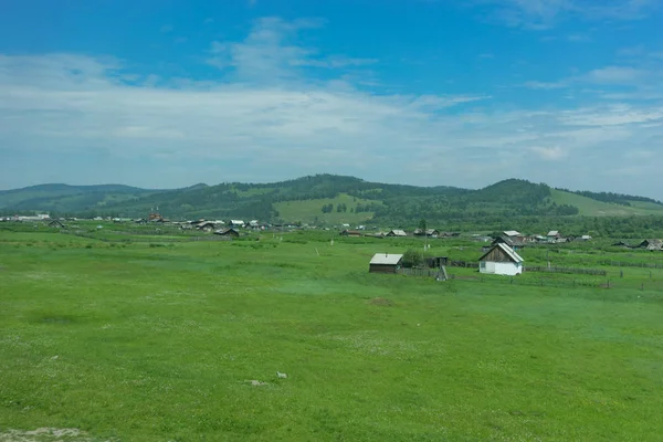 Rural landscape with houses, fields and mountains