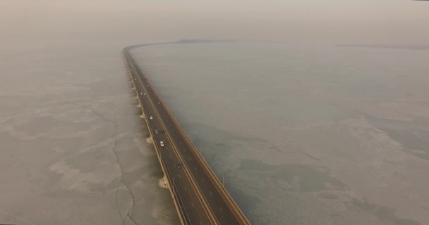 Landscape with a field of ice of the Amur Bay and the bridge Sedanka-De Vries overlooking the coastline and the city. Vladivostok, Russia — Stock Footage Landscape Field Ice Amur Bay Bridge Sedanka Vries Overlooking Coastline Video Clip