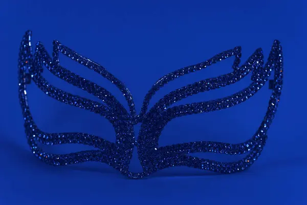 A mask made of blue crystals on a blue background..