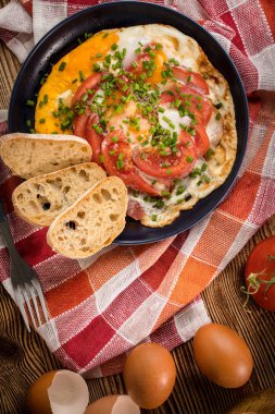 Ev yapımı kahvaltı yumurta ile domates ahşap masa üzerinde kızarmış. Üstten görünüm.