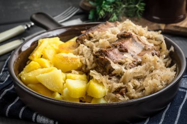 Kızarmış patatesle servis edilen lahana turşulu pirzola..