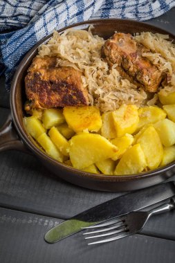 Kızarmış patatesle servis edilen lahana turşulu pirzola..