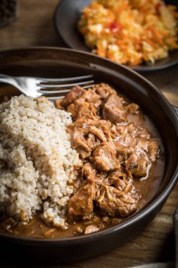 Bir tavada pişirilmiş etli arpa kabuğu çıkarılmış tane servis.