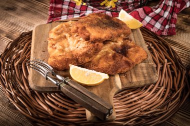 Kırıntıları bir kesme tahtası üzerinde kızarmış morina fileto.