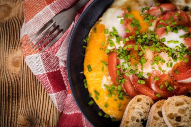 Ev yapımı kahvaltı yumurta ile domates ahşap masa üzerinde kızarmış. Üstten görünüm.