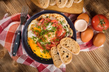 Ev yapımı kahvaltı yumurta ile domates ahşap masa üzerinde kızarmış. Üstten görünüm.