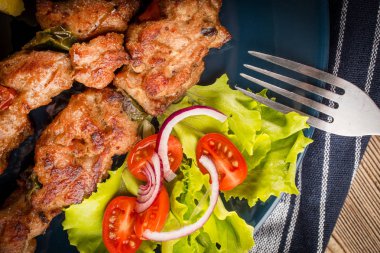 Şiş kebap - ızgara et, kızarmış patates ve sebze.