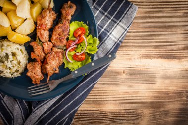 Şiş kebap - ızgara et, kızarmış patates ve sebze. Üst görünüm.