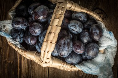 Ahşap masa üzerinde bir hasır basketl Bahçe Erik.