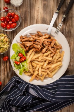 Yunan jiroskopu, patates kızartması ve tabakta salata. Üst görünüm.