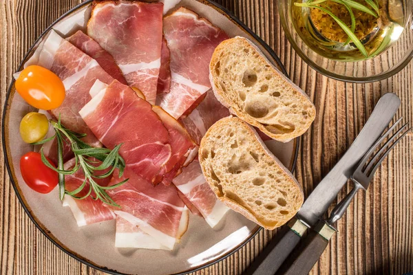 İnce dilimlenmiş ciabatta ekmeği, domates, zeytin ile Alman kara orman jambon dilimlenmiş. Üstten görünüm.