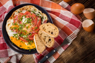 Ev yapımı kahvaltı yumurta ile domates ahşap masa üzerinde kızarmış. Üstten görünüm.
