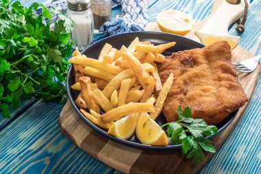 Tabağında patates kızartması olan kızarmış morina balığı..