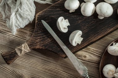 Ahşap Doğrama tahtası üzerinde taze çiğ mantar. Üstten görünüm.