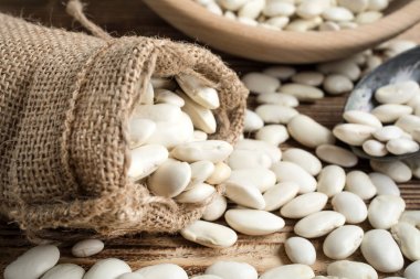 Ahşap bir masa üzerinde Jüt çuval içinde fasulye.