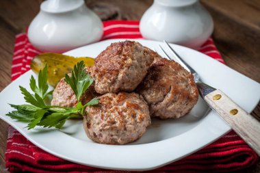 Kızarmış domuz eti köfte beyaz bir plaka üzerinde.