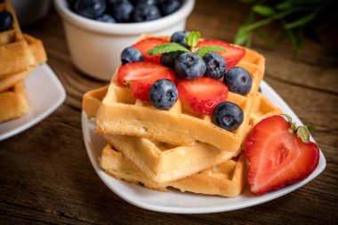 Bir tabak meyve ile waffle yığını. Küçük alan derinliği.