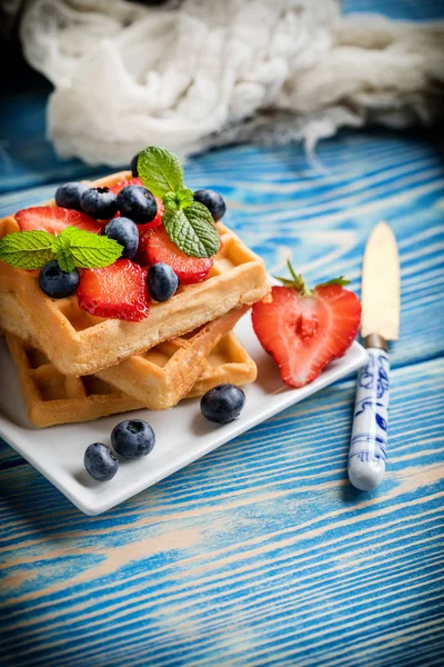 Stack of waffles with fruit on a plate. Small depth of field.
