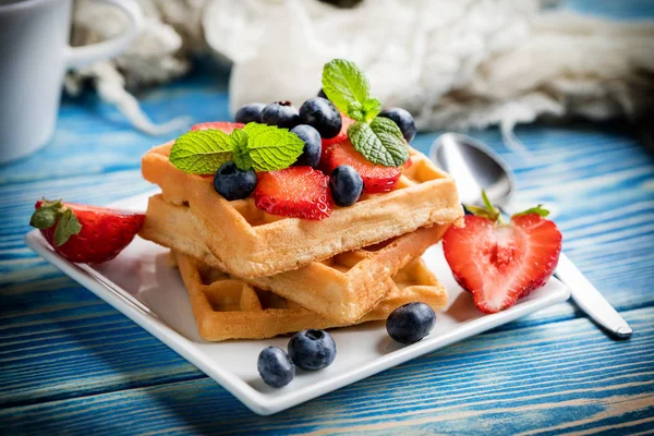 Stack of waffles with fruit on a plate. Small depth of field.