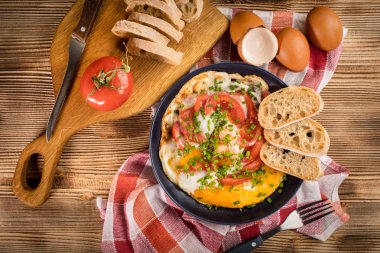 Ev yapımı kahvaltı yumurta ile domates ahşap masa üzerinde kızarmış. Üstten görünüm.