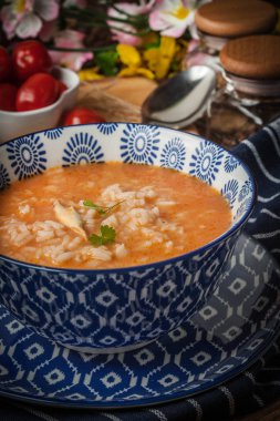 Mavi bir kase pilav ile taze domates çorbası.