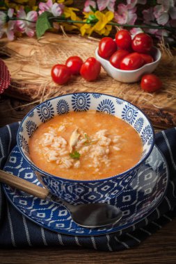 Mavi bir kase pilav ile taze domates çorbası.