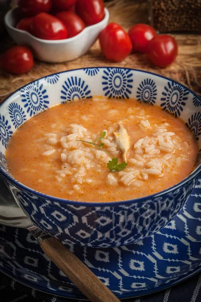 Mavi bir kase pilav ile taze domates çorbası.