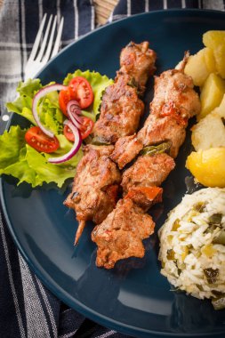 Şiş kebap - ızgara et, kızarmış patates ve sebze.