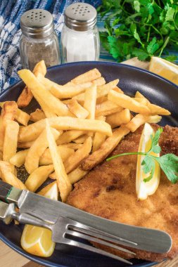 Tabağında patates kızartması olan kızarmış morina balığı..