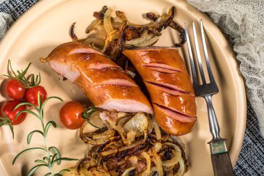 Onionson bir tabak kızarmış sosis. Üstten görünüm.