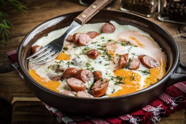 Yumurta tavaya doğranmış sosis ile pişmiş lezzetli.