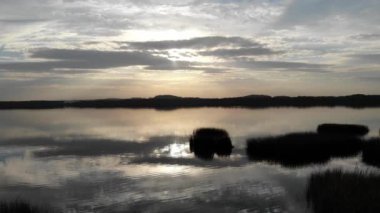 Göl kenarında romantik günbatımı.