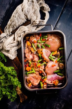 Bir kavurma tavada sebzeli tavuk eti pişirme için hazırlanan.