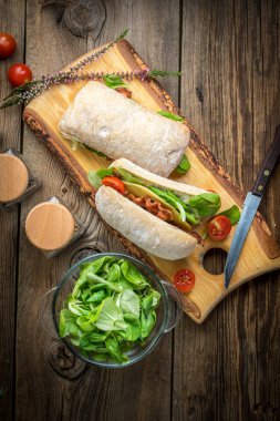 Ciabatta ahşap tahta üzerinde Roka Salatası, pastırma ve sarı peynirli sandviç. Üstten Görünüm.