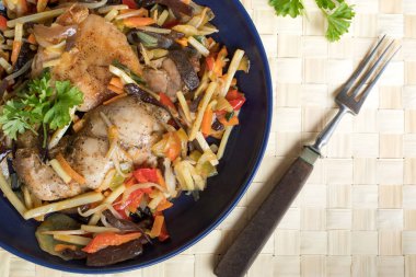 Plaka üzerinde sebzeli tavuk fileto.