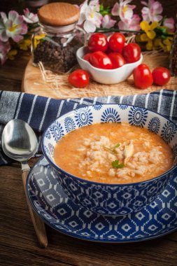 Mavi bir kase pilav ile taze domates çorbası.