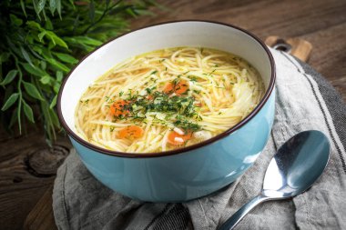 Suyu - tavuk çorbası ile mavi bir kase erişte..