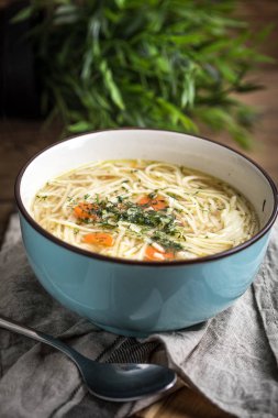 Suyu - tavuk çorbası ile mavi bir kase erişte..